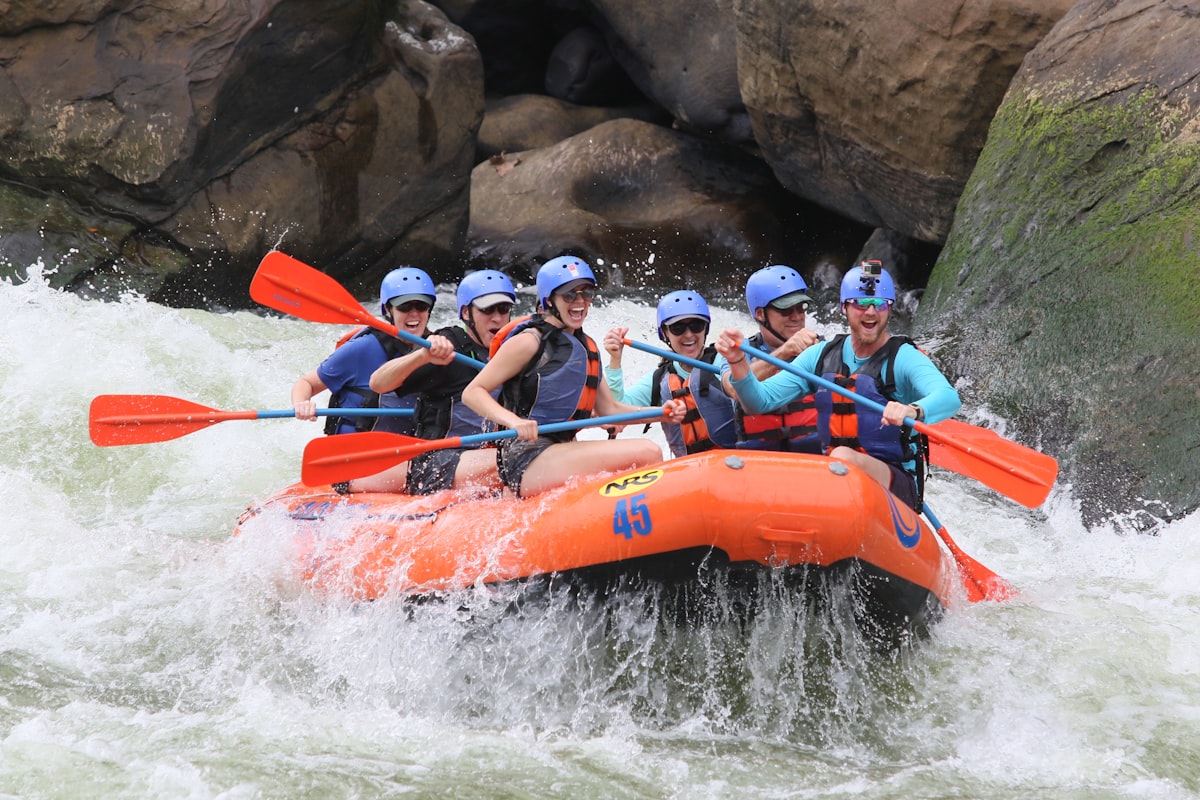 Grupo de turistas haciendo rafting en aguas bravas río ecuatoriano