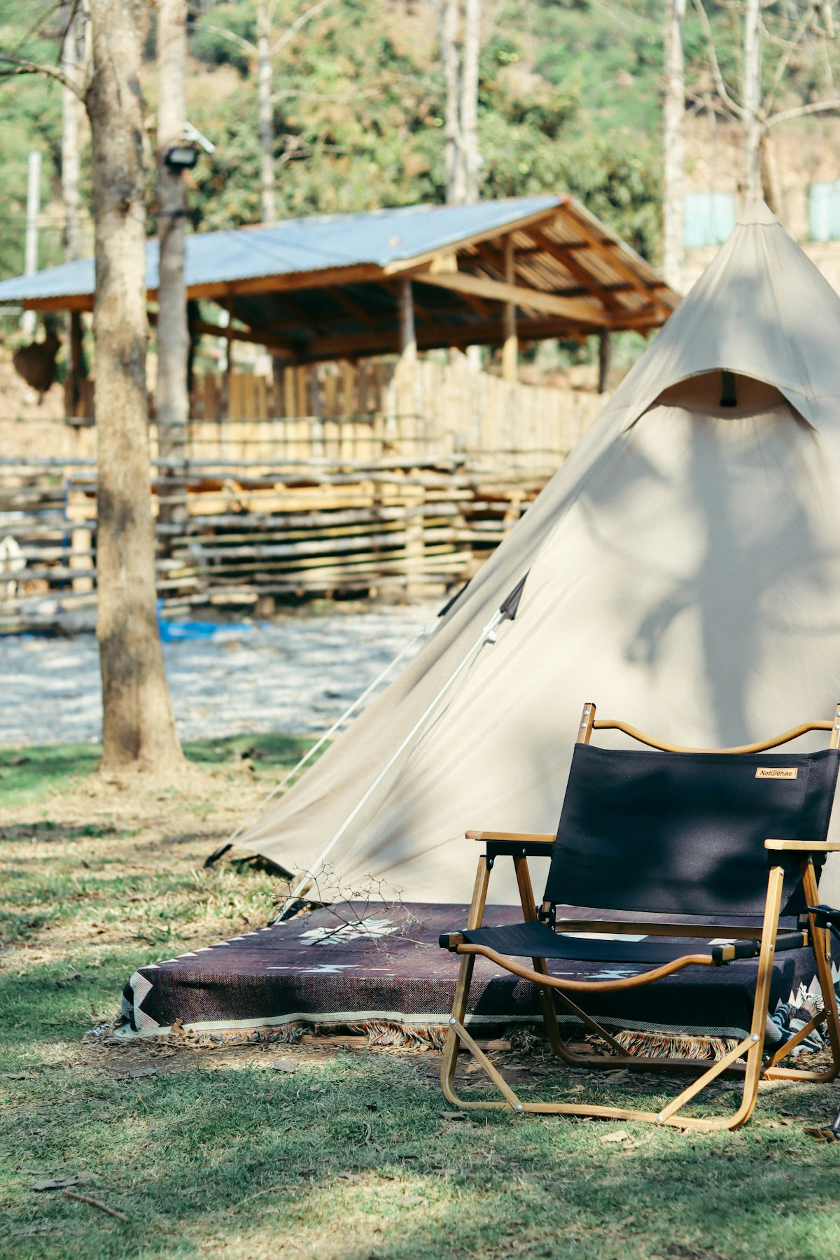 Tienda de glamping de lujo con silla de madera en paisaje natural verde en Ecuador