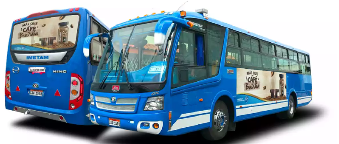 Vista frontal de 2 buses del corredor Norte Centro Quito con publicidad en la parte posterior visible al tráfico vehicular